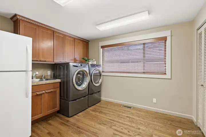 Extra-large laundry room with built-in cabinetry & utility sink.