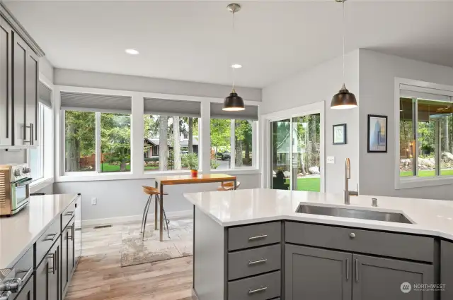 The kitchen opens to the eating nook and looks out to the lush backyard.