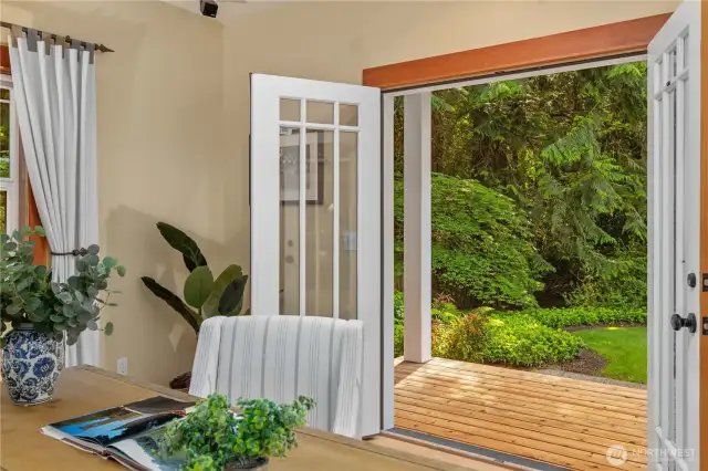 The covered deck off the den/family room offers lovely views of the beautifully landscaped grounds.