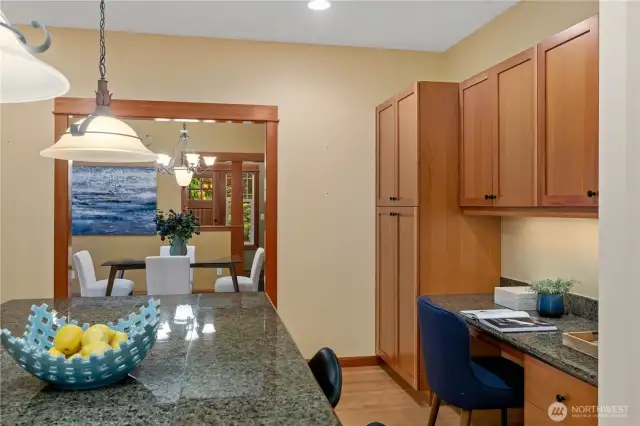 The large pantry on the right and cabinets above the built-in desk provide plenty of storage options.