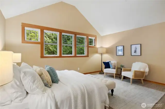 Another view of the primary bedroom highlighting the large bank of windows.