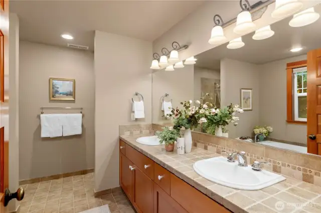 The primary bath includes double sinks with plenty of counter space, and a large soaking tub which over looks the lush surroundings.