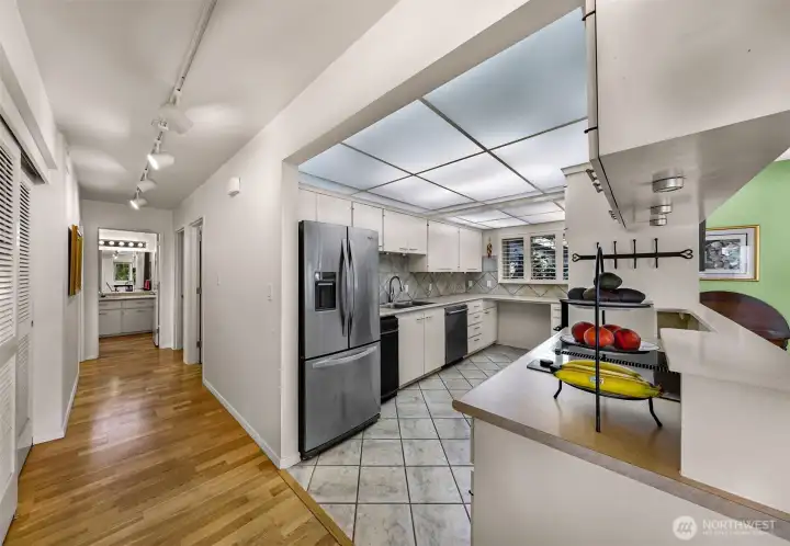 Plenty of storage throughout, hallway with additional closet leading to utility room, bedrooms and baths
