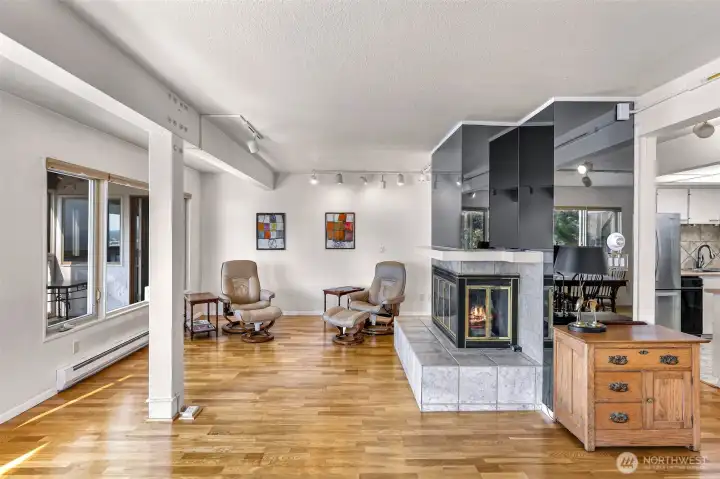 Looking into second half of the large main living space, this cozy fireplace compliments the area so well!