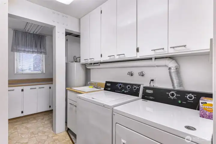 Extra large utility room with tons of extra storage space, additional counter space and wash basin style sink.