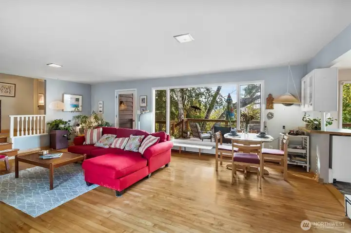 Bright, open living area with large windows, hardwood floors, and seamless flow into the dining space. Perfect for entertaining.