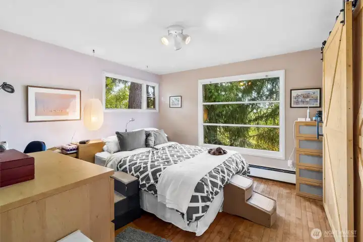 Spacious primary suite with serene views, abundant natural light, and comfortable space for a restful retreat.