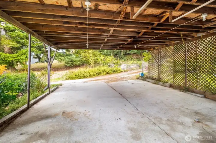 Covered carport provides convenient parking and protection from the elements.
