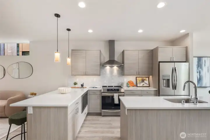 Large kitchens in both plans.  Each kitchen features BOTH an island AND peninsula + stainless appliance package + stone backsplash + quartz-topped counters + amazing storage + under cabinet lighting + separate dining spaces.