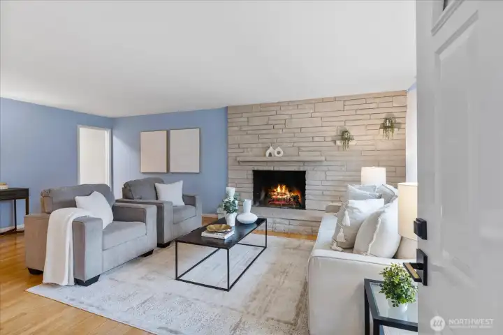 Open concept living to dining room space allows for easy entertaining while enjoying views from the picture windows in front of the wood burning fireplace.