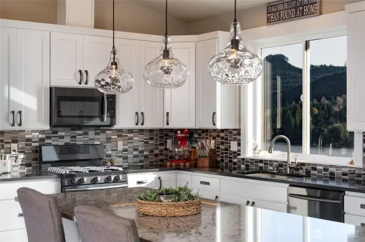 Modern kitchen with island, pendant lights, and lake views