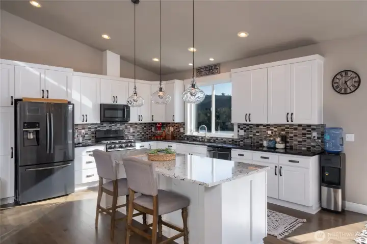 Modern kitchen with island, quartz counters, and pendant lights
