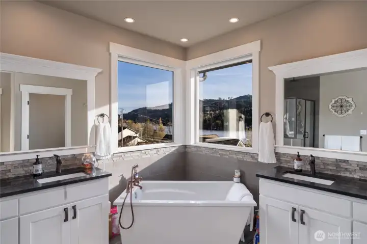Spa-style bathroom with soaking tub and dual vanities