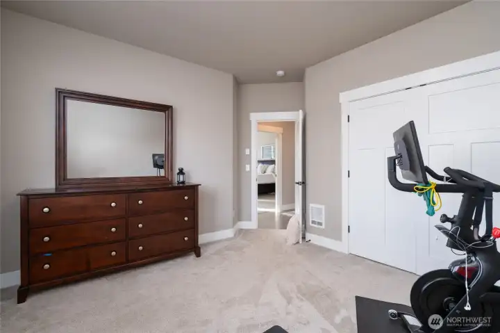 Versatile bonus room with dresser, mirror, and fitness space