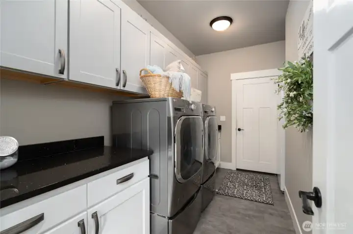 Spacious laundry room with storage cabinets and appliances