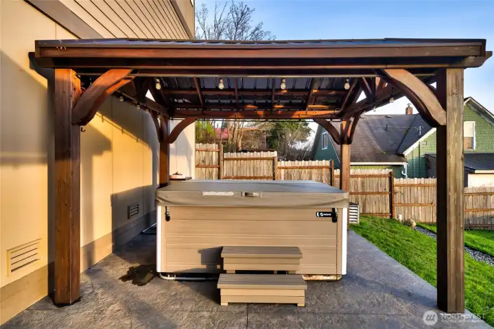 Private hot tub under pergola with fenced backyard retreat