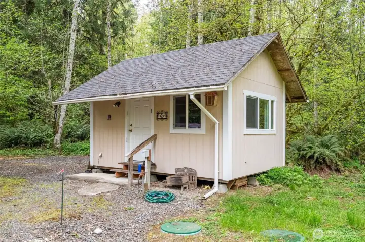 Right side view of cabin. RV hookups conveniently located next to entry.