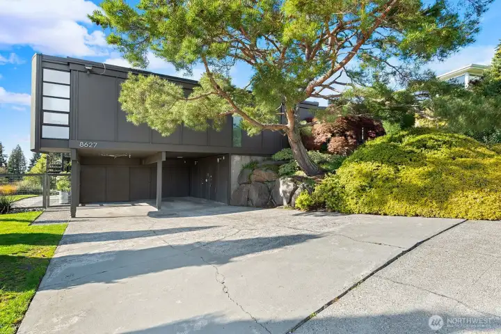 Striking mid century modern exterior surrounded by mature landscaping