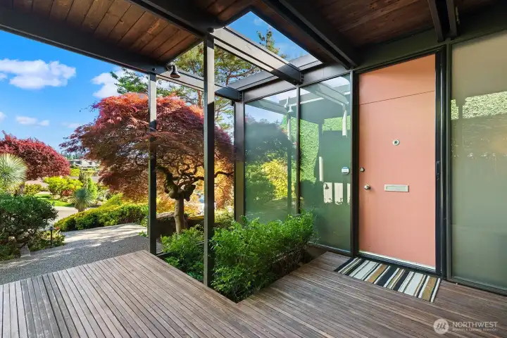 Light-filled entry with modern lines and frosted glass for privacy and style, surrounded by thoughtfully designed landscaping