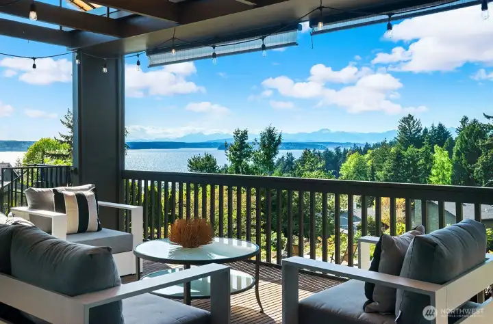 Expansive covered deck with panoramic water and mountain views—perfect for year-round entertaining