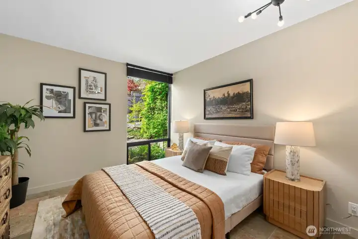 Inviting bedroom with clean lines, modern lighting, generous closet space and garden views