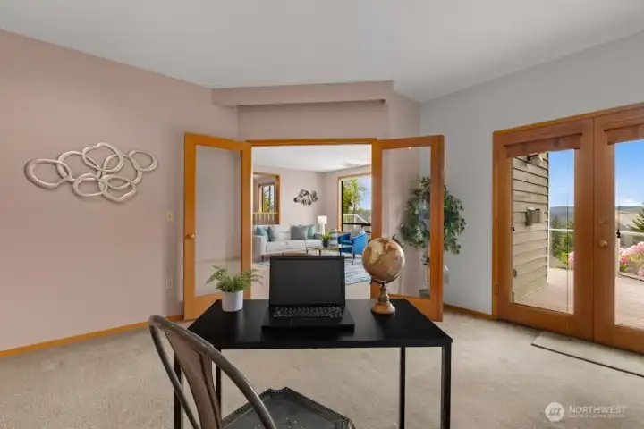French doors frame the transition to an expansive wraparound deck.
