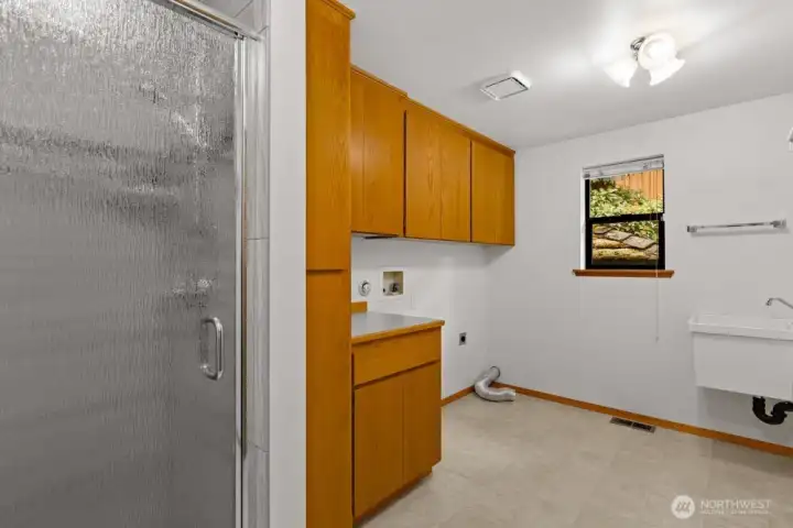 The large laundry room includes a utility sink and shower, ideal for washing off muddy paws or cleaning up after outdoor projects.