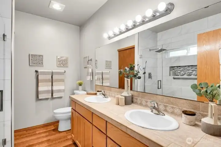 Dual vanities and a spectacular new shower stall highlight the primary bathroom
