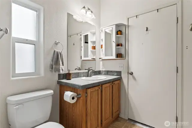 Bright bathroom with ample storage, medicine cabinet, and natural light.