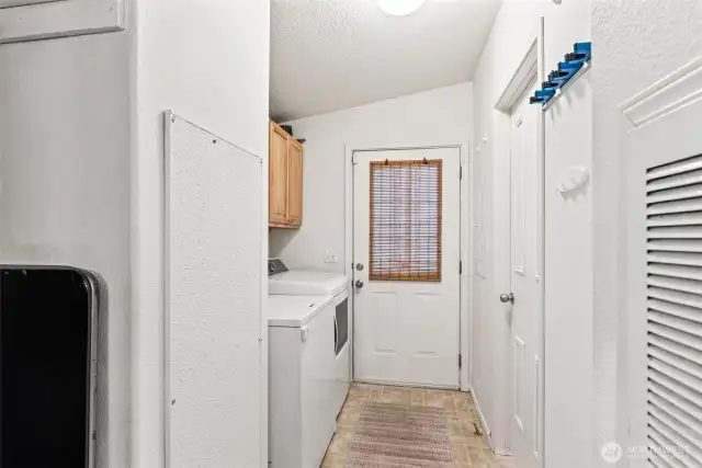Dedicated laundry space with overhead cabinetry and exterior access.