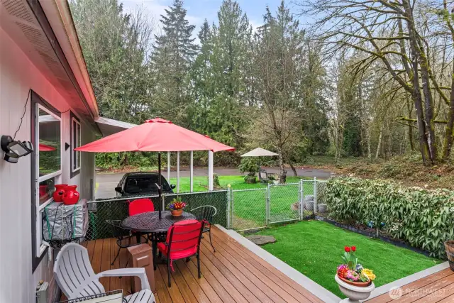 Entertain or unwind on the spacious composite deck, surrounded by low-maintenance artificial turf, privacy fencing, and peaceful green space.