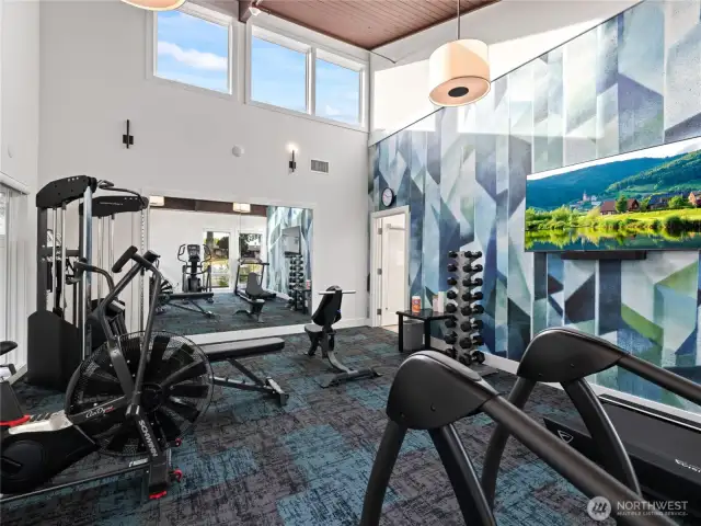 Stay active in the well-equipped fitness room featuring cardio, strength training equipment, and inspiring design.