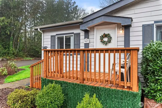 A fresh, NEW front porch welcomes you home with curb appeal galore, enhanced by mature shrubs and decorative touches.