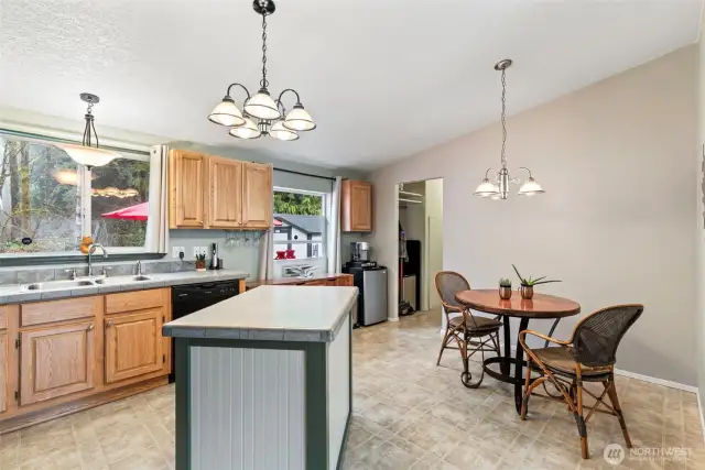 Open-concept kitchen and dining space featuring a stylish light fixture and breakfast nook.