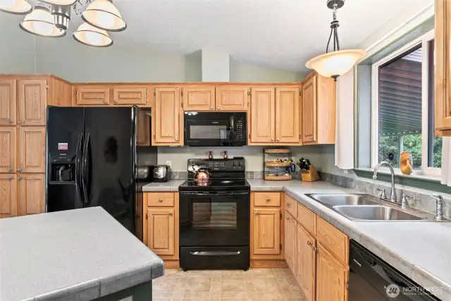 Dual sink setup with large windows offering natural light and views of the backyard.