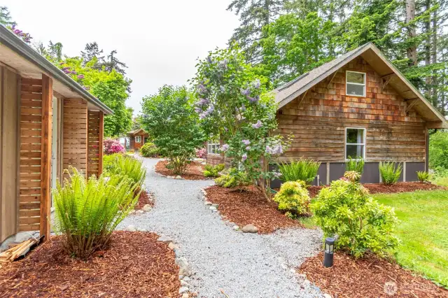 Storage building on left, bunk house on right. Path leads to main house.