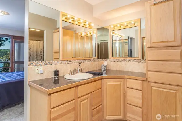 Primary bathroom has ample storage - and leads you to the primary room