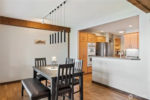 Modern light fixture in dining room plus open to kitchen