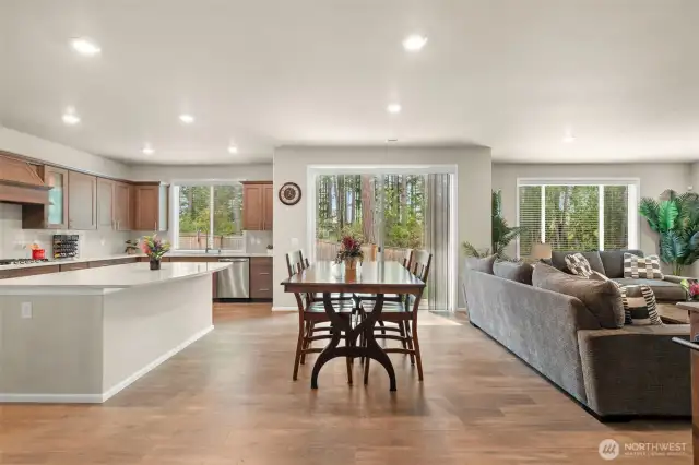 Spacious open-concept living with seamless flow from the kitchen to the dining and great room—perfect for entertaining, everyday living, and enjoying the view of the private, tree-lined backyard.