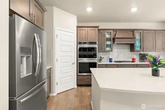 A closer look at the gourmet kitchen reveals a sleek stainless steel French-door fridge, double wall ovens, and a walk-in pantry—thoughtfully designed to inspire your inner chef.