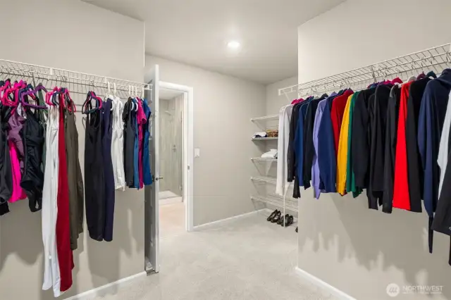 Dream closet alert! This expansive walk-in closet offers built-in shelving, double hanging racks, and direct access to the ensuite bath—keeping your wardrobe organized and easily accessible