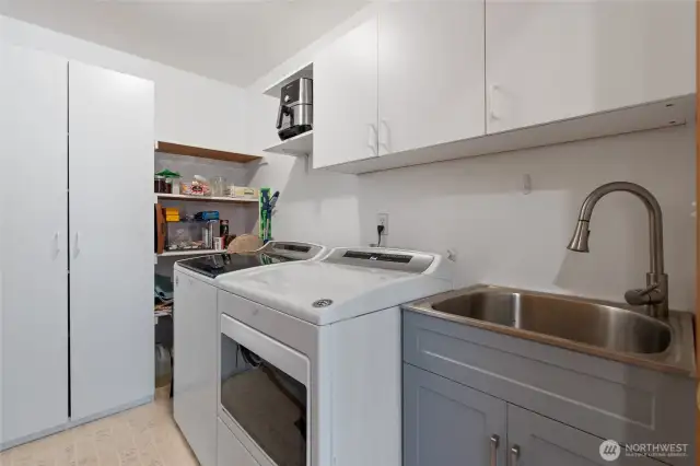 Laundry with a sink and pantry shelves.