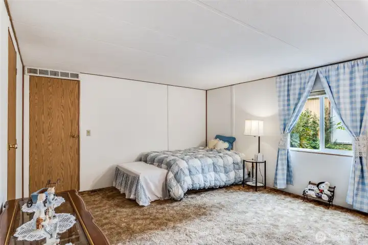 Private primary suite with vaulted ceiling and large window for natural light.