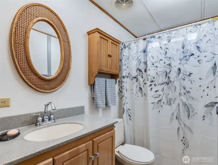Full guest bathroom with shower-tub combo and updated finishes.