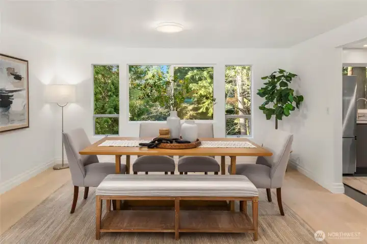 Dining room adjacent to the kitchen, with views of the lush, green backyard.