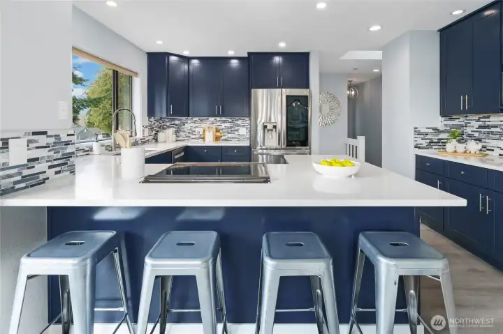 New kitchen with beautiful navy cabinets, quartz, designer tile, induction range, special vent hood flush to the ceiling and coffee bar!