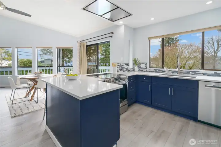 New kitchen with beautiful navy cabinets, quartz, designer tile, induction range, special vent hood flush to the ceiling and coffee bar!