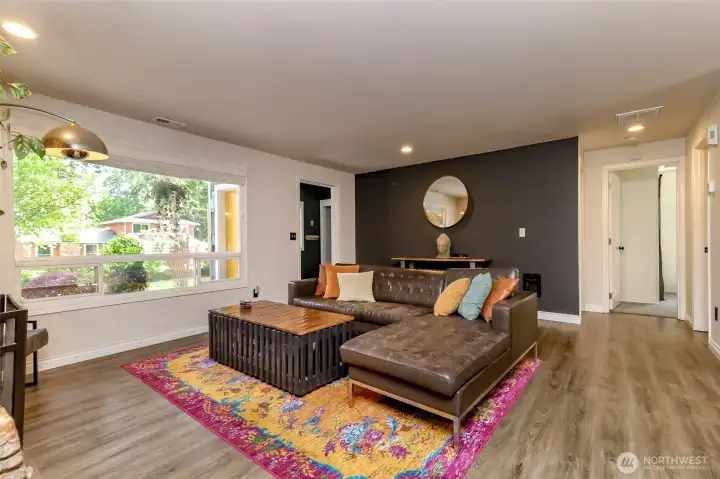 Great room featuring an open-concept layout that seamlessly connects the living, kitchen, and dining areas. Highlights include beautiful laminate flooring throughout, creating a perfect heart of the home.