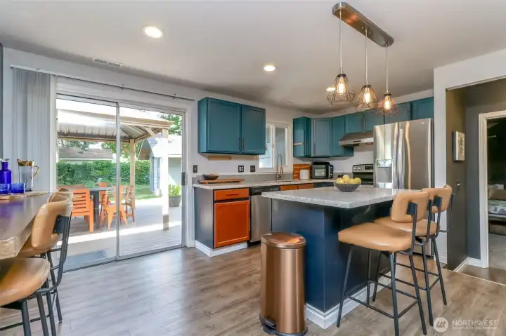 This kitchen features a unique, custom-painted design and beautiful laminate flooring. Included bar stools are available for the new homeowners.