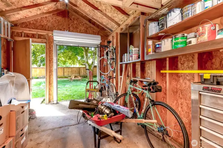 Workshop or shed featuring a convenient roll-up door, perfect for storing bikes, kayaks, lawn equipment, or tools. Provides ample extra storage space.